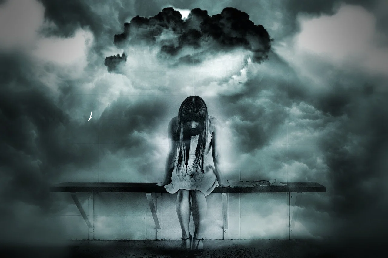 image in black and white showing young woman sitting alone in fear on bench with heavy clouds behind her A New Outlook Recovery Services Colorado