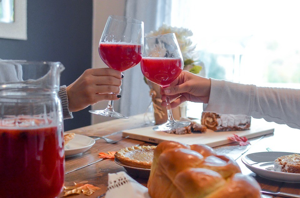 two people clink glasses with red fruit punch